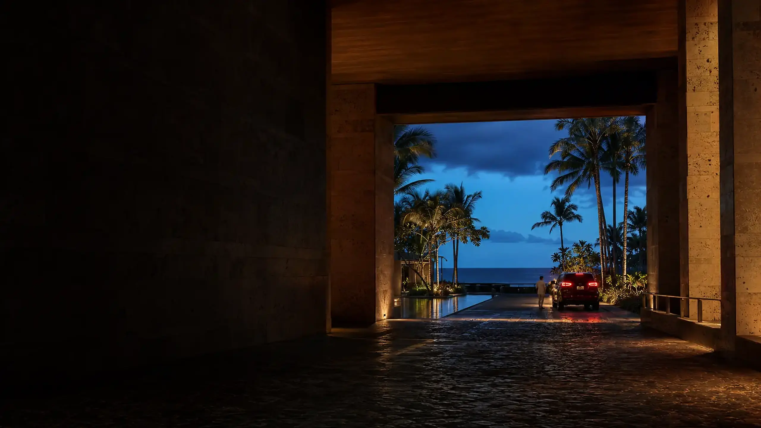 Luxury coastal resort arrival framed by warm architecture at blue hour
