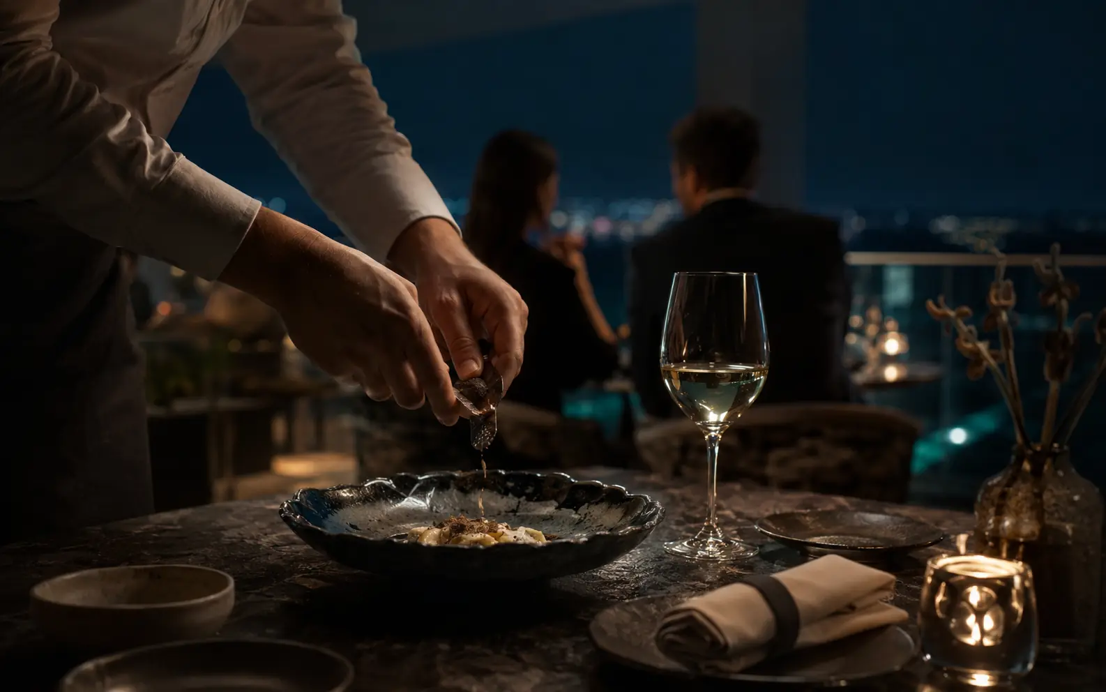 Precise tableside hospitality ritual in a destination restaurant at night
